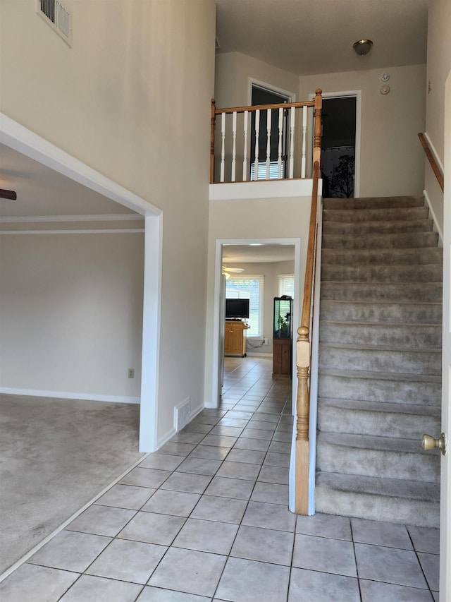 staircase with tile patterned floors and ceiling fan