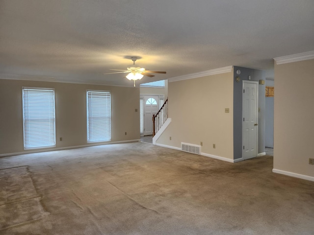 carpeted spare room with a wealth of natural light, crown molding, and ceiling fan