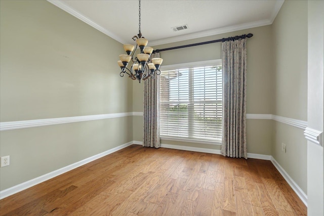 empty room featuring light wood-type flooring, an inviting chandelier, and crown molding