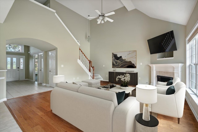 living room with hardwood / wood-style flooring, high vaulted ceiling, plenty of natural light, and ceiling fan