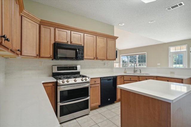 kitchen with kitchen peninsula, sink, light tile patterned floors, and black appliances