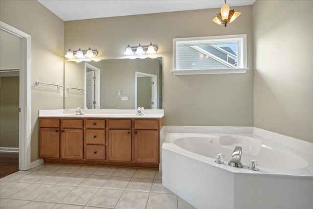 bathroom featuring tile patterned flooring, a washtub, and vanity