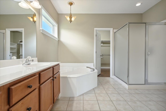 bathroom with tile patterned flooring, shower with separate bathtub, and vanity