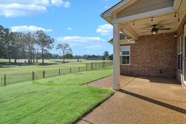 view of yard featuring a patio area, ceiling fan, and a rural view