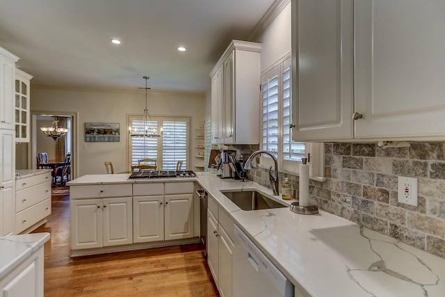 kitchen featuring tasteful backsplash, white cabinets, sink, and white dishwasher