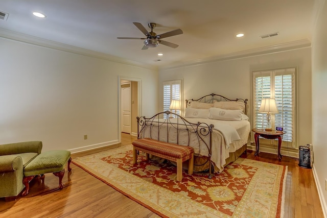 bedroom with hardwood / wood-style flooring, ceiling fan, ornamental molding, and multiple windows