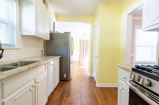 kitchen featuring sink, stainless steel appliances, light stone counters, dark hardwood / wood-style flooring, and white cabinets