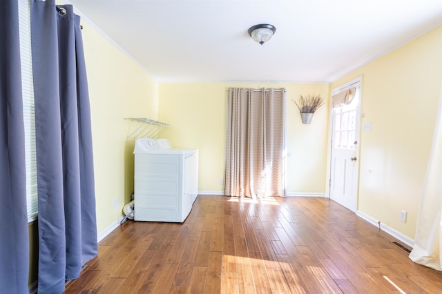 clothes washing area with hardwood / wood-style floors and washer / clothes dryer