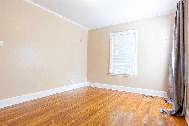 empty room featuring hardwood / wood-style floors and ornamental molding