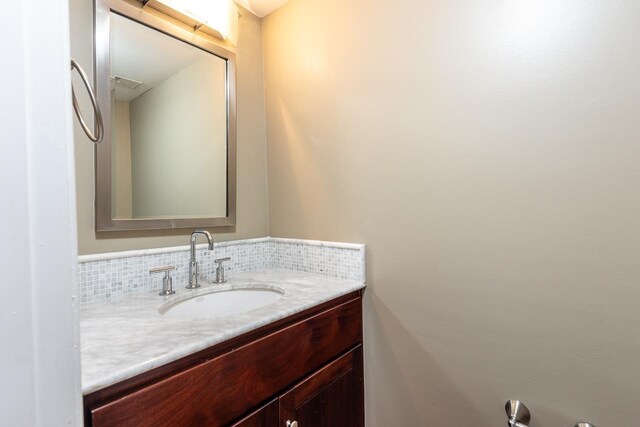 bathroom featuring vanity and decorative backsplash