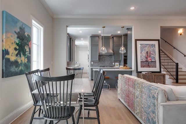 dining room featuring light hardwood / wood-style flooring and ornamental molding