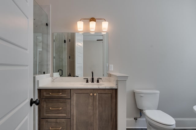 bathroom featuring toilet, vanity, and walk in shower