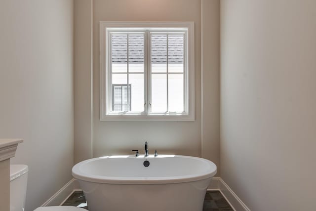 bathroom with tile patterned flooring and a tub