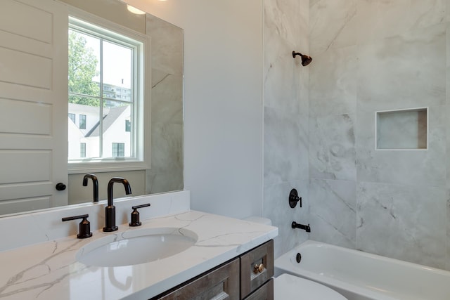 full bathroom with vanity, tiled shower / bath combo, and toilet