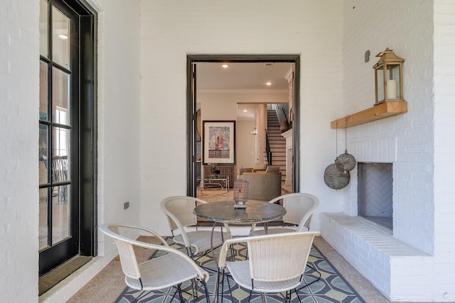 carpeted dining space with ornamental molding