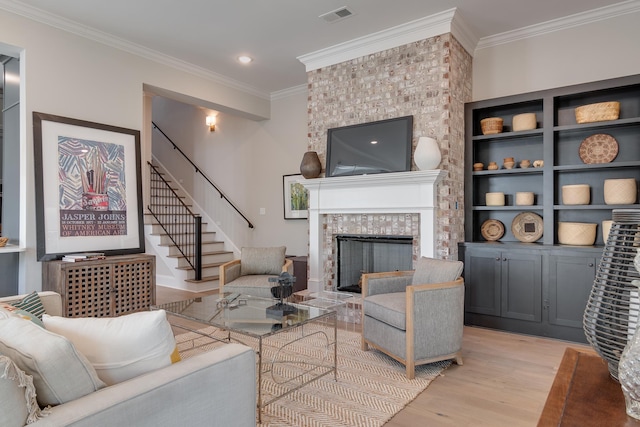 living room featuring a fireplace, light hardwood / wood-style floors, and crown molding