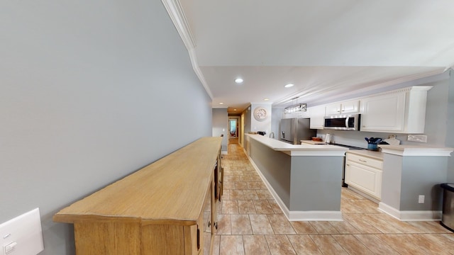 kitchen with stainless steel appliances, white cabinetry, light tile floors, and crown molding