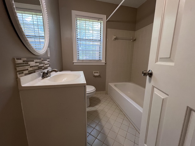 full bathroom with tile patterned floors, vanity, tiled shower / bath combo, and toilet