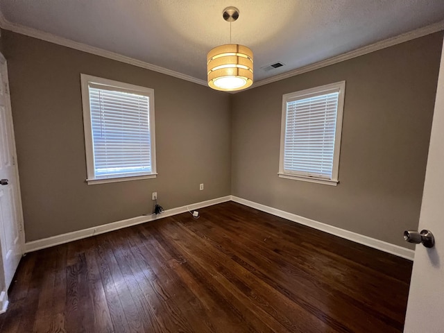 spare room featuring crown molding, dark wood-type flooring, and a textured ceiling