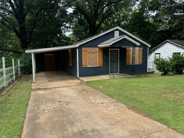 view of front of home with a carport and a front lawn