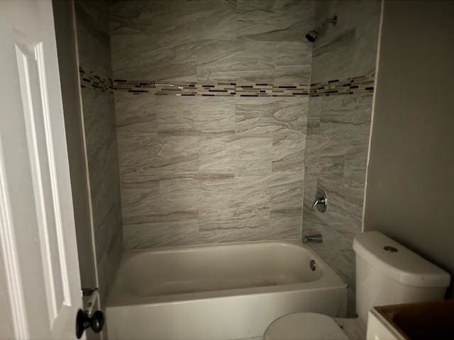 bathroom with toilet and tiled shower / bath combo