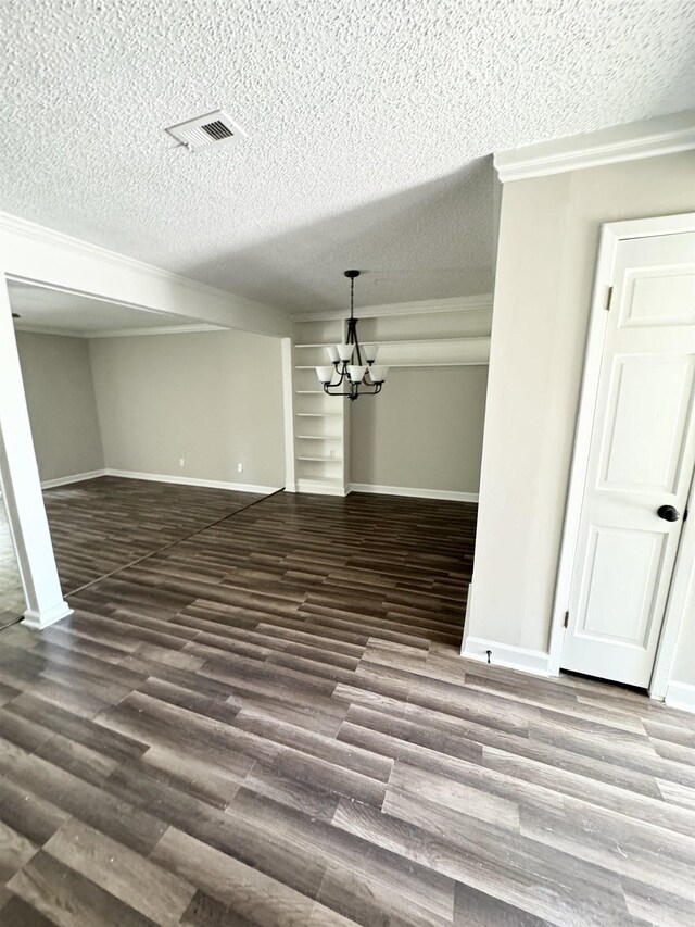 interior space featuring a textured ceiling, dark hardwood / wood-style flooring, and an inviting chandelier