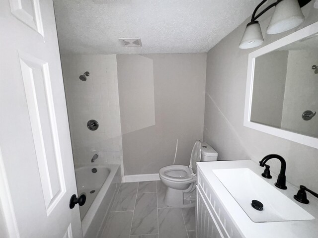 full bathroom featuring a textured ceiling, vanity, toilet, and tiled shower / bath