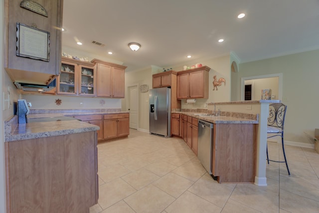 kitchen with a kitchen bar, kitchen peninsula, appliances with stainless steel finishes, crown molding, and sink