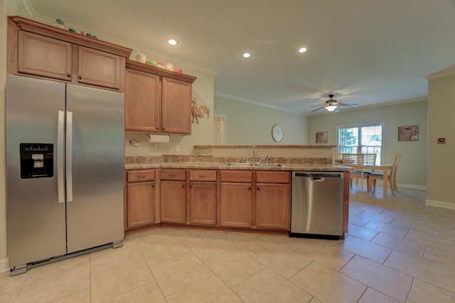 kitchen featuring ceiling fan, sink, crown molding, stainless steel appliances, and light stone counters