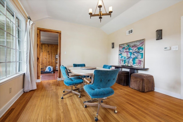 office area with light hardwood / wood-style floors, vaulted ceiling, and a chandelier