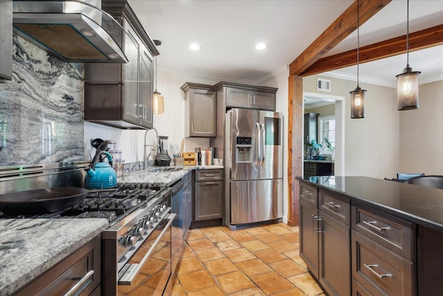 kitchen featuring wall chimney range hood, hanging light fixtures, stainless steel appliances, tasteful backsplash, and light tile floors