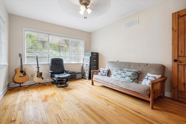 living room featuring ceiling fan and light hardwood / wood-style flooring