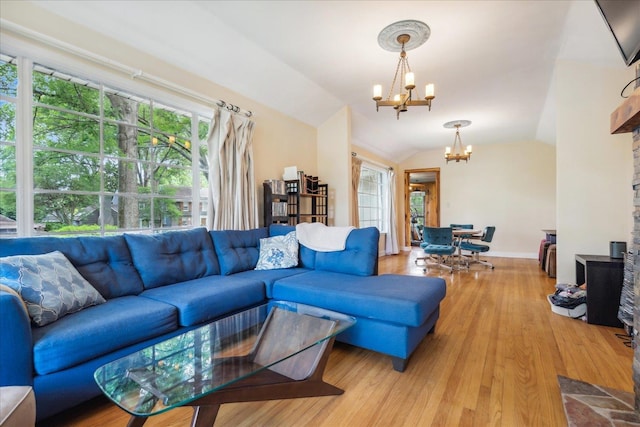 living room featuring vaulted ceiling, wood-type flooring, and a chandelier