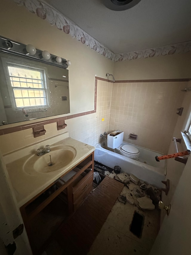 full bathroom with tiled shower / bath combo, tile walls, backsplash, toilet, and vanity