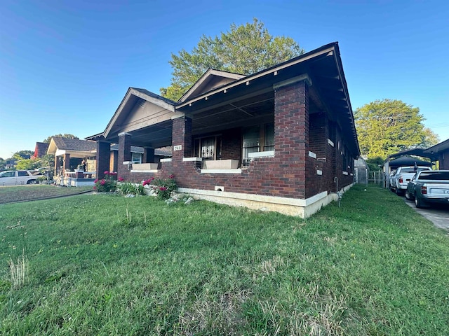 view of side of home featuring a lawn and a porch