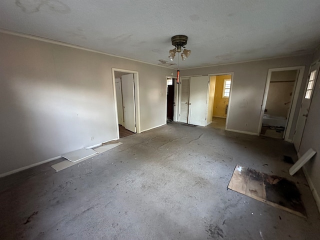 unfurnished bedroom with ceiling fan, a textured ceiling, and ensuite bath