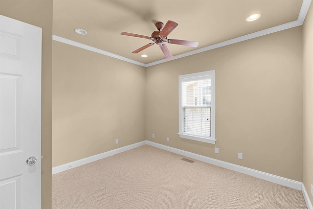 unfurnished room featuring ceiling fan, light colored carpet, and ornamental molding