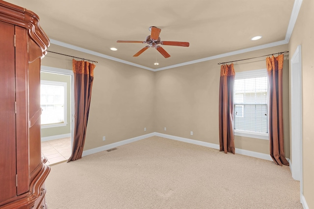 carpeted empty room with crown molding and ceiling fan