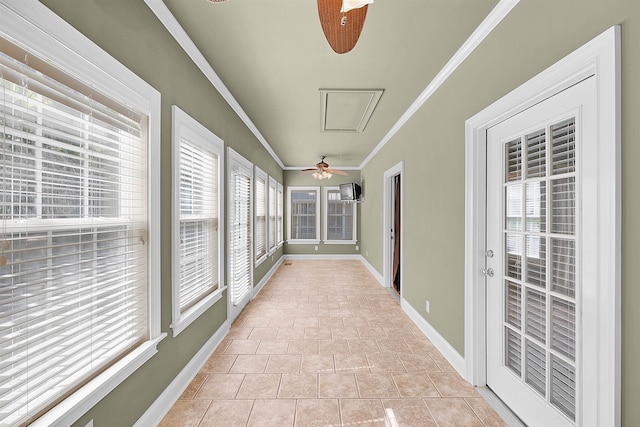 unfurnished sunroom featuring ceiling fan