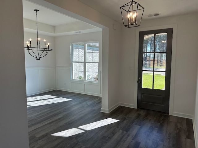 foyer entrance featuring dark wood-type flooring and a chandelier