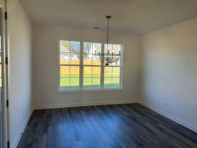 unfurnished dining area featuring dark wood-type flooring and a notable chandelier