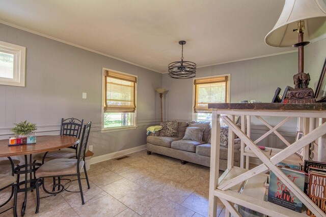 tiled dining area with a chandelier and crown molding