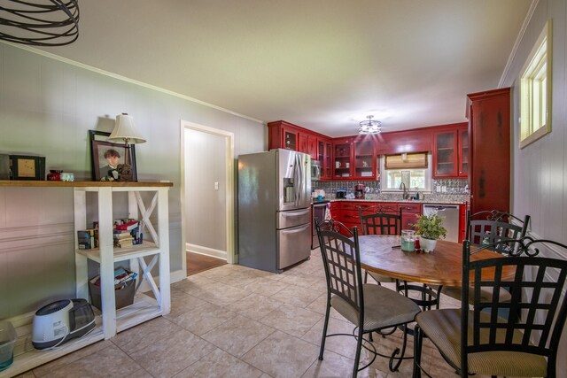 dining area featuring ornamental molding and light tile patterned flooring