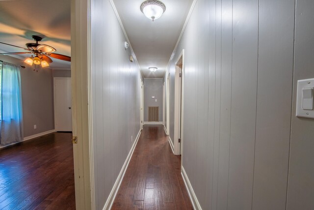 corridor with dark hardwood / wood-style floors and ornamental molding