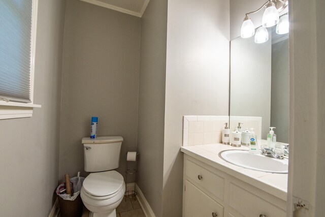 bathroom featuring tile patterned floors, crown molding, vanity, and toilet