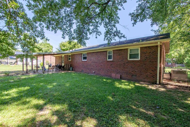 rear view of property featuring a patio area, a yard, and central air condition unit