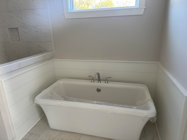 bathroom featuring a tub and a healthy amount of sunlight