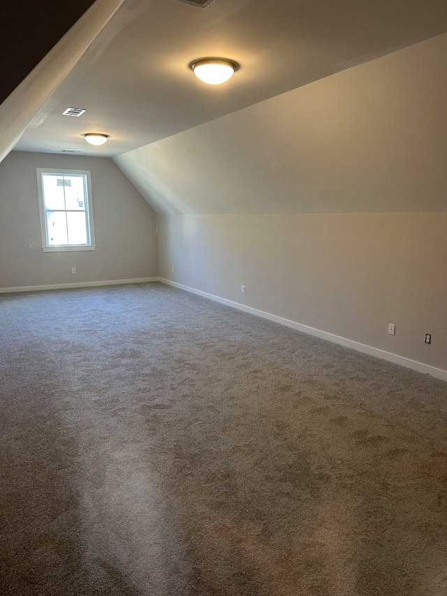 bonus room with carpet floors and vaulted ceiling