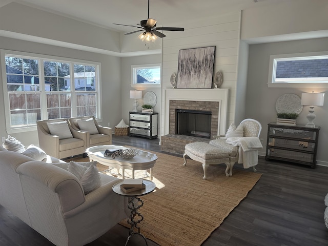 living room featuring a brick fireplace, ceiling fan, and dark wood-type flooring