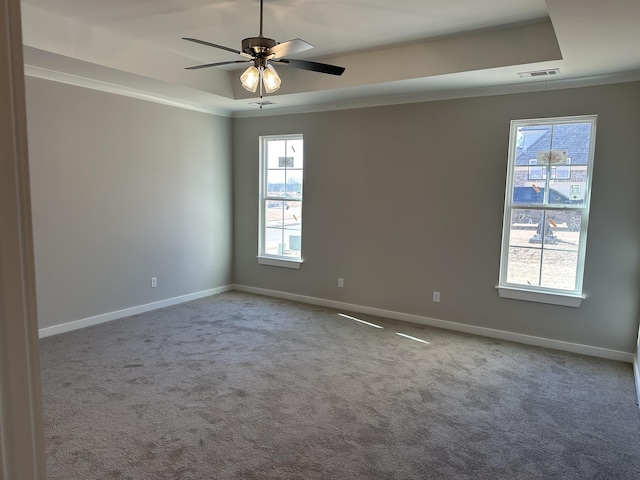 empty room featuring carpet floors, ornamental molding, a raised ceiling, and ceiling fan